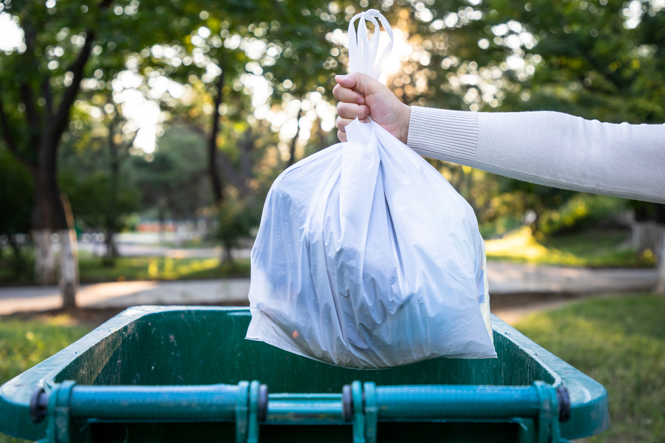 Throw the garbage bag into the trash can