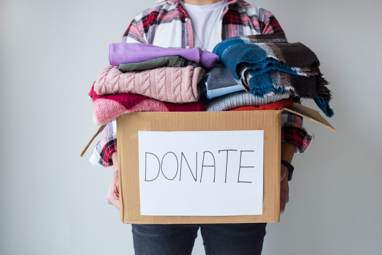 Man holding a clothes donate box. Donation concept.